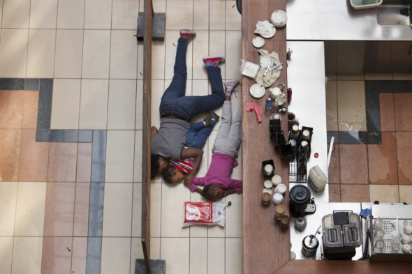 A woman and children hide inside Westgate Mall in Nairobi, Kenya, Sept. 21, 2013.