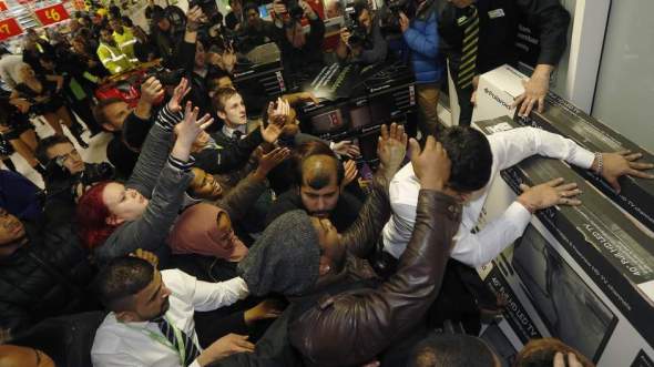 Shoppers compete to purchase retail items on "Black Friday" at an Asda superstore in Wembley, north London
