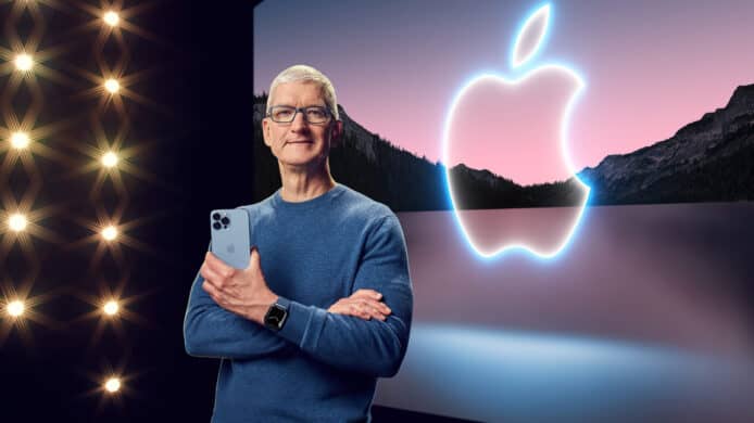 Apple CEO Tim Cook holding an iPhone, with an Apple logo in the background