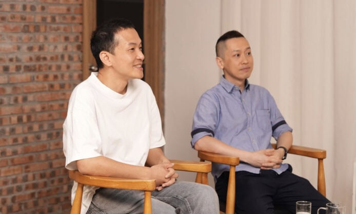 兩名男子在座談會上聊天並微笑.