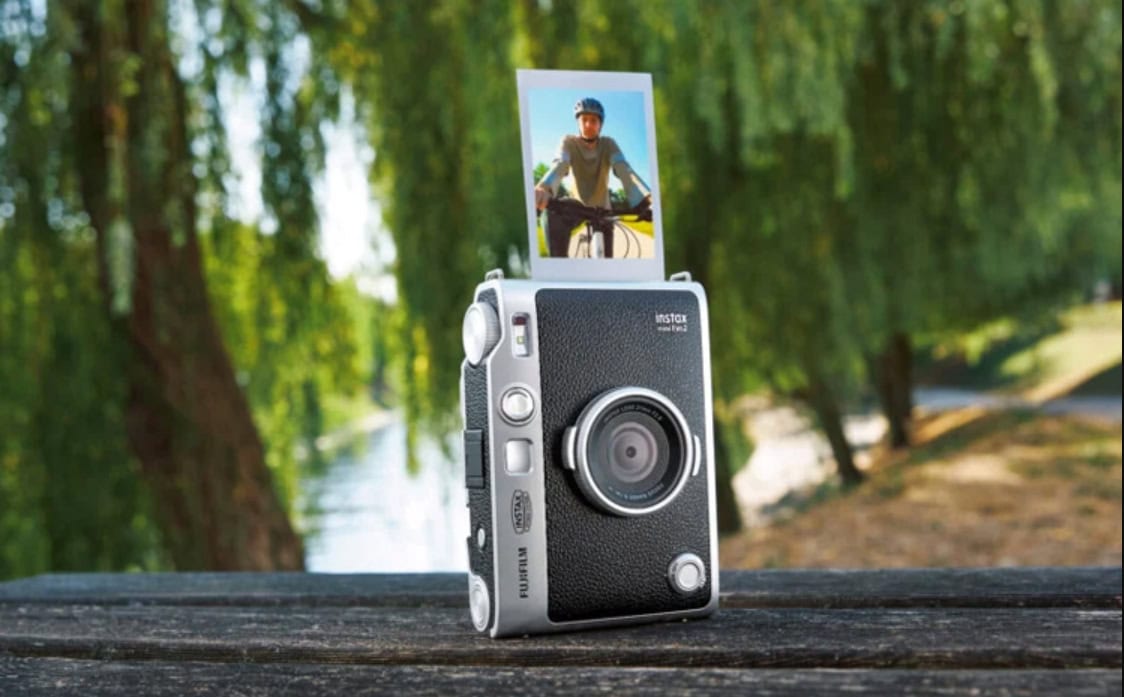 Instax Mini Evo 2 輕巧相機於長木桌上.