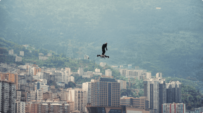 綠魔飛行滑板在空中飛行，背景是城市和山脈.
