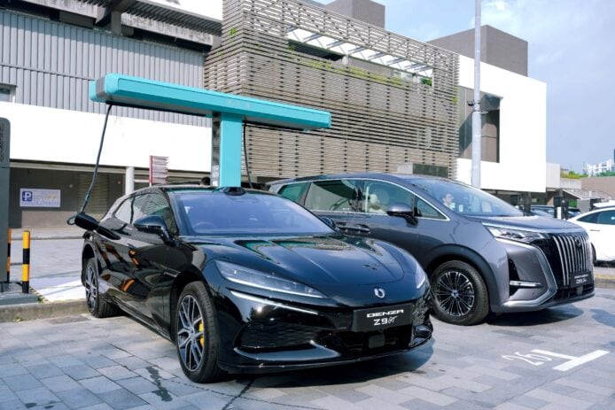 黑色電動跑車與亮藍充電樁在城市景觀.