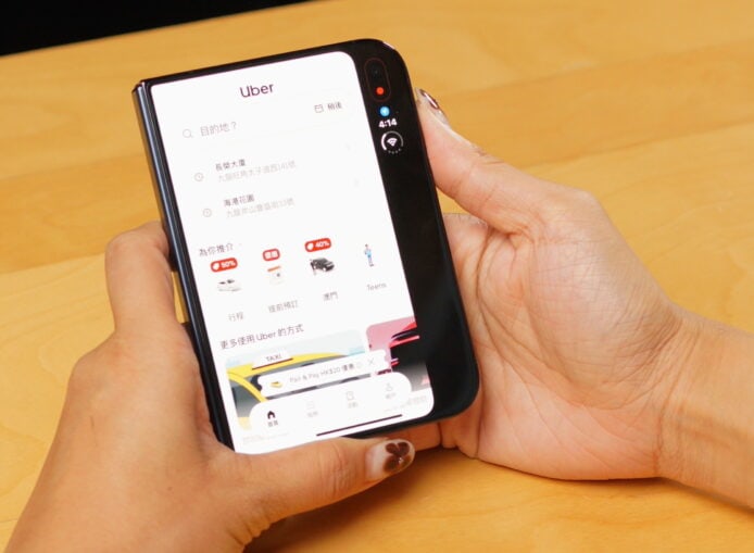 手持 iPhone 顯示 Uber 應用界面.
