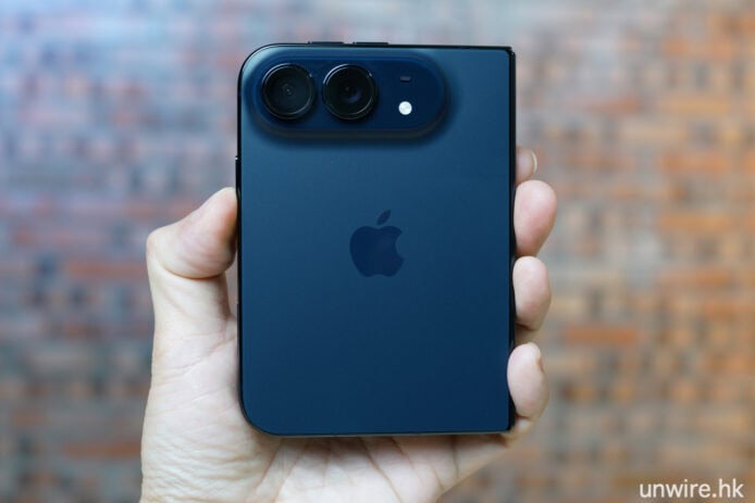 手持藍色 iPhone 拍攝，後蓋鏡頭特寫.