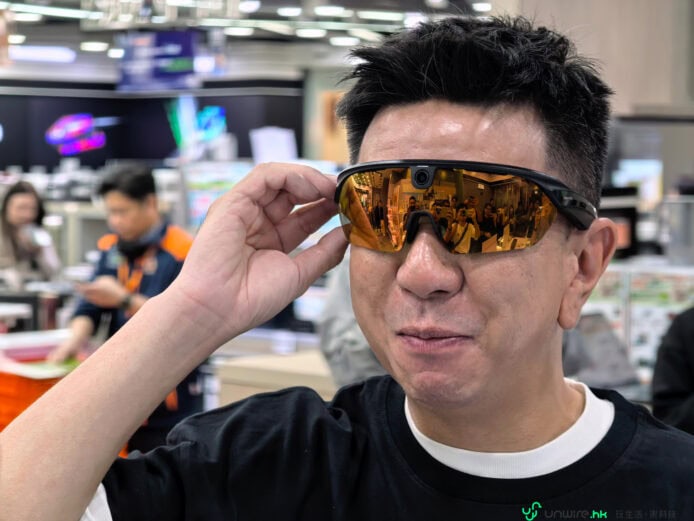 高科技眼鏡展示現場 佩戴者戴着偏光橙色鏡片運動眼鏡在展會現場.