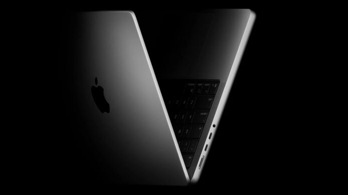 黑色MacBook Pro部分開啟展示鍵盤與側邊接口.